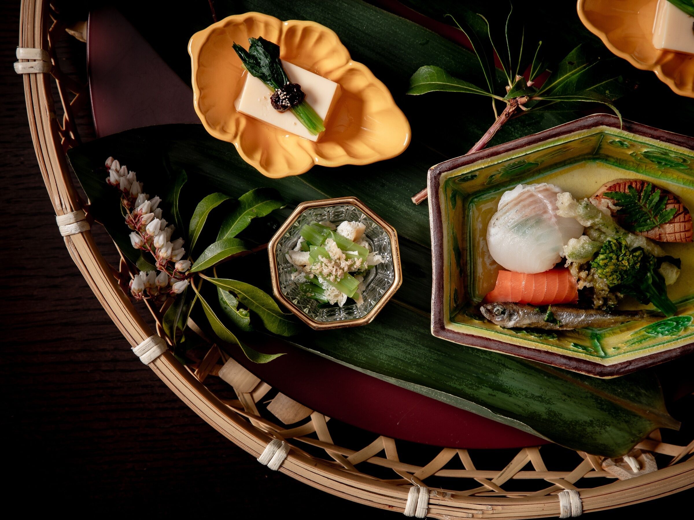 A traditional Japanese meal with various dishes on a woven tray.