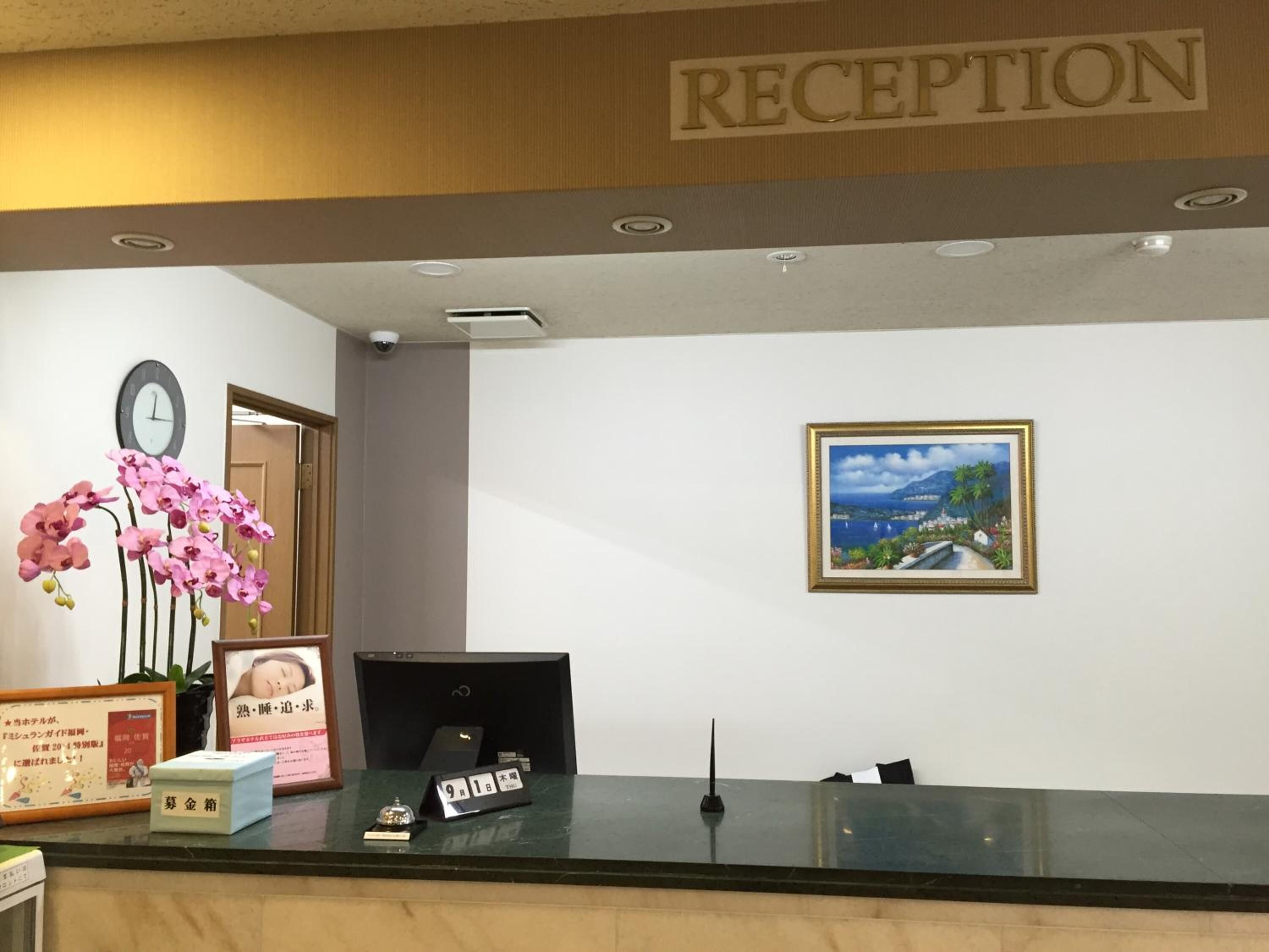A reception area with a clock, a framed picture, and a sign that reads "RECEPTION".