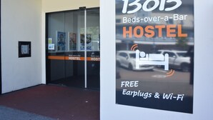 A hostel entrance with a sign advertising free earplugs and Wi-Fi. - BoBs Hostel (Taupo)