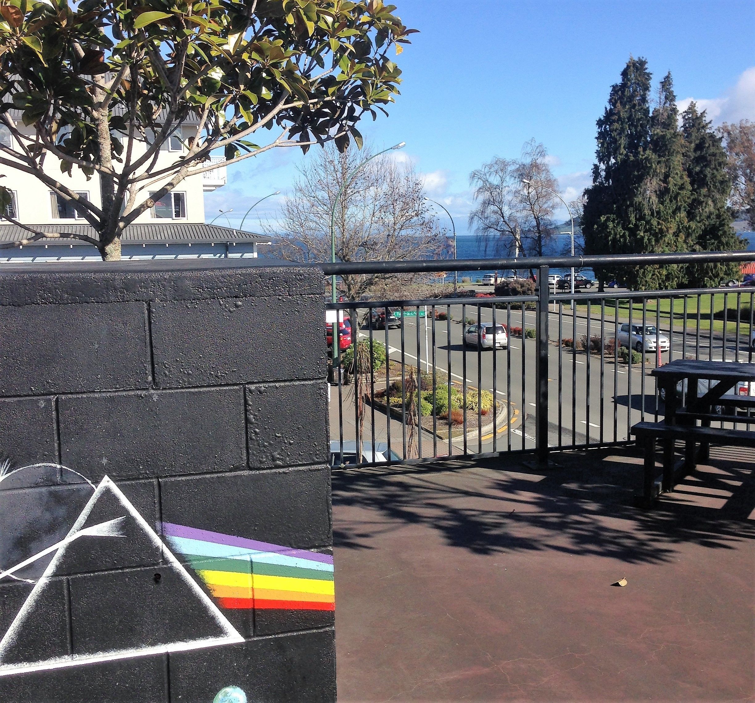 A paved area with a black wall featuring a rainbow-colored design.