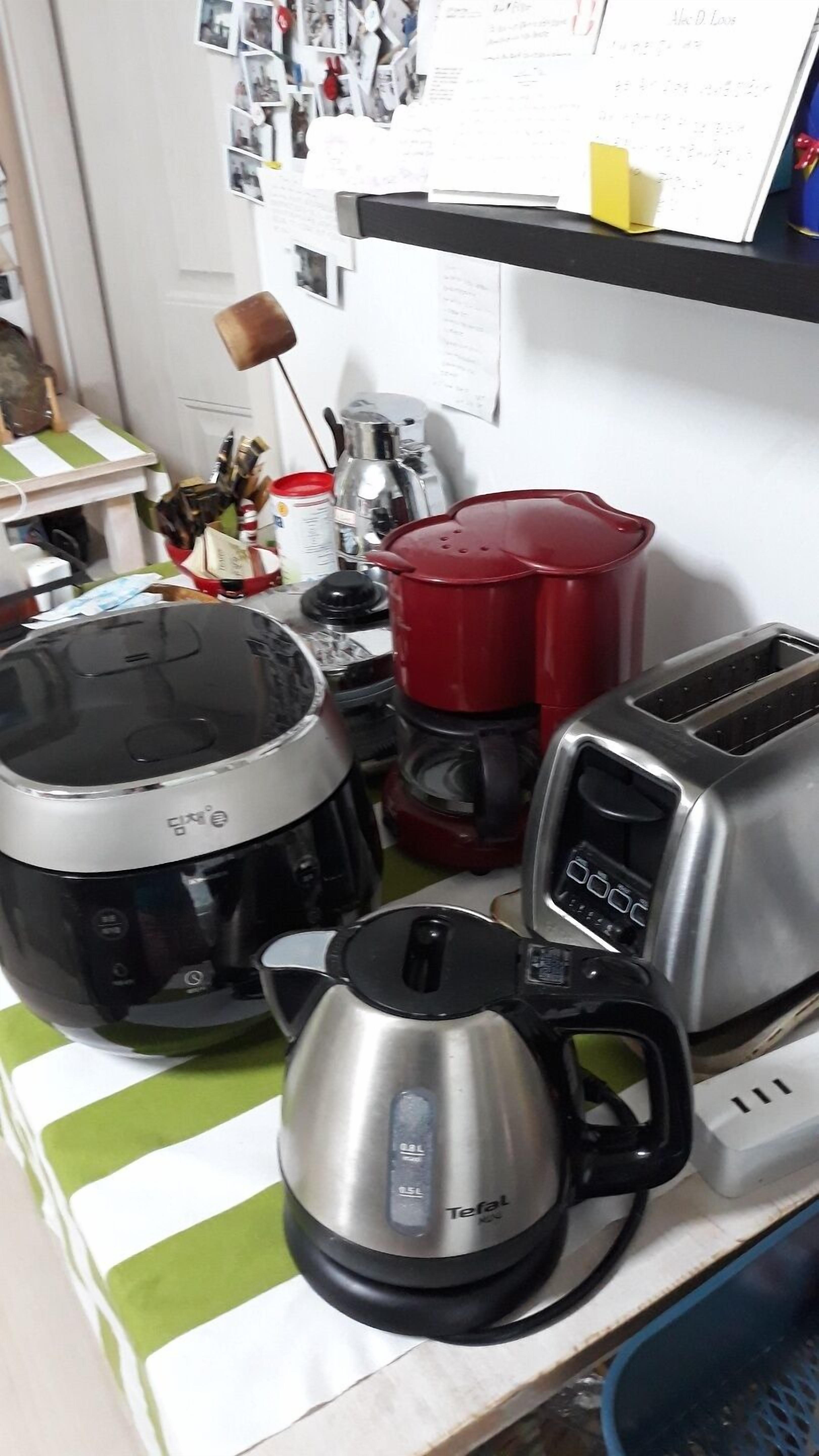 A kitchen counter with a coffee maker, a toaster, and a rice cooker.