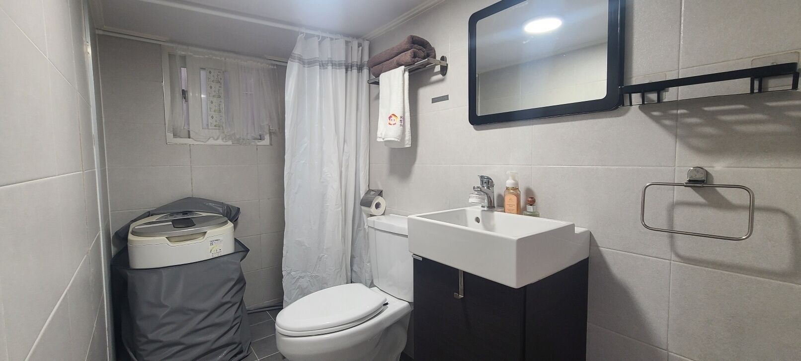 A small bathroom with a toilet, sink, and shower curtain.