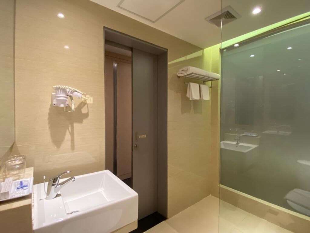 Une salle de bain moderne avec un grand lavabo, une douche à parois de verre et un porte-serviettes.