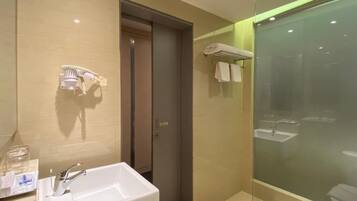 Une salle de bain moderne avec un grand lavabo, une douche à parois de verre et un porte-serviettes.