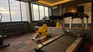 Un gimnasio con equipo de ejercicio, una cinta de correr y mancuernas.