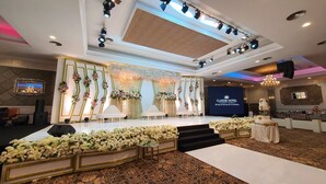 Un escenario con fondo para un evento hotelero, con una gran pantalla mostrando el nombre del hotel.