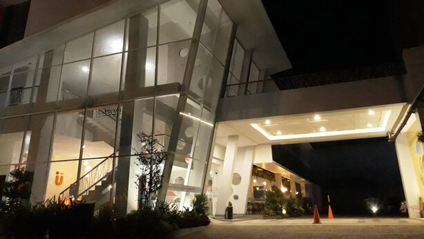 A modern building with a glass facade, a staircase, and outdoor seating area. - Urban Style Hotel Lampung, Azana Hotels Collection (Gedongtataan)