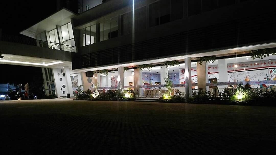 A modern hotel with a spacious lobby, large windows, and a well-lit entrance.