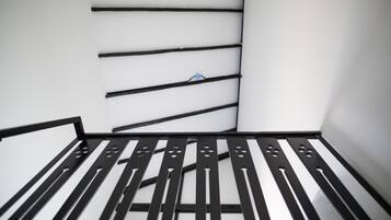 A room with a metal bed frame and a white wall.