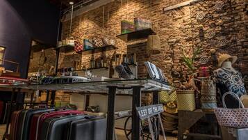 A luggage store with suitcases, handbags, and decorative items against a brick wall backdrop.