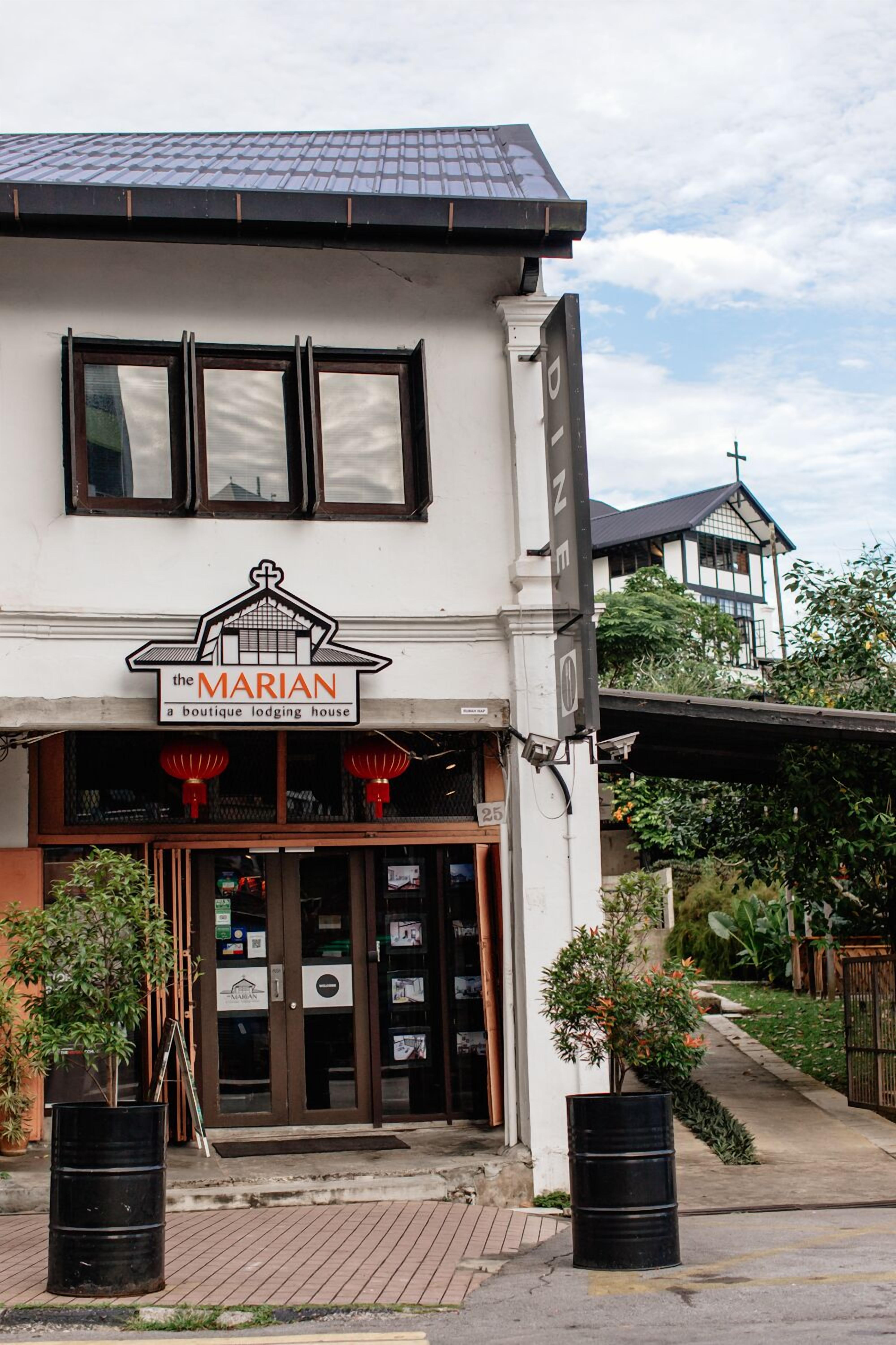 A boutique lodging house named 'The Marian' with a traditional architectural style, featuring a prominent entrance with double doors and a signboard above.