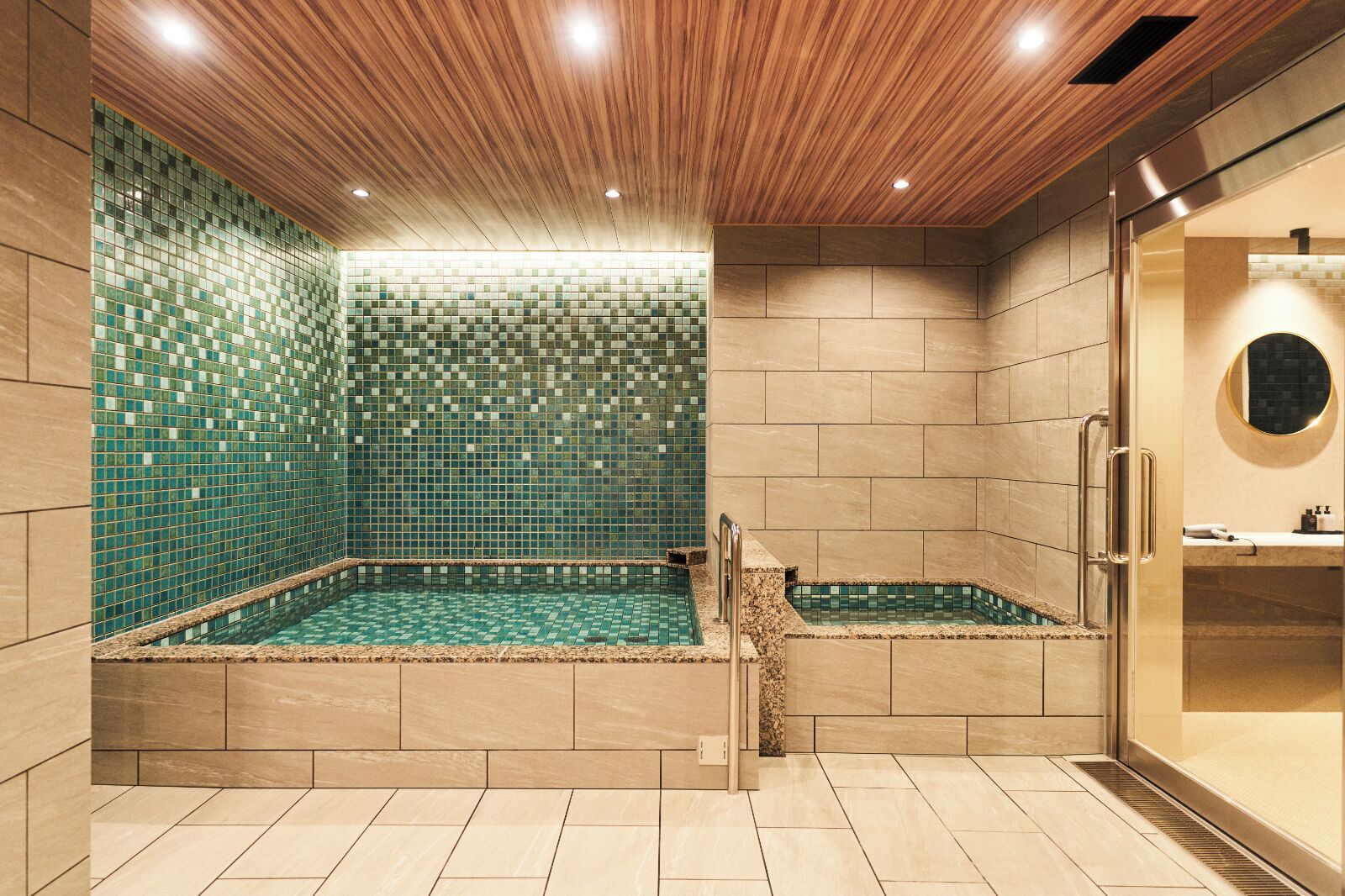 A modern bathroom with a wooden ceiling, tiled walls, a built-in bathtub, and a glass shower enclosure.