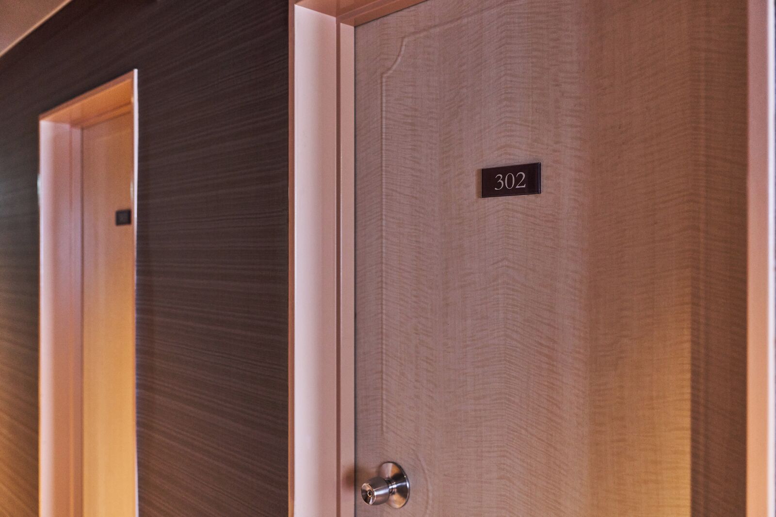 Une porte de chambre d’hôtel avec une plaque indiquant le numéro 302.