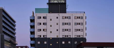 A hotel building with a sign reading 'HOTEL GLOBAL VIEW' and a modern architectural design.