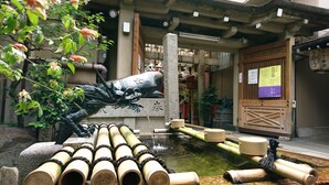 A traditional Japanese garden with a koi pond, bamboo arrangements, and a stone lantern.