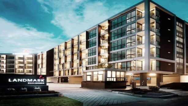 A modern hotel with a prominent 'Landmark Residence' sign, featuring a multi-story structure with large windows and a well-lit entrance. - Landmark Residence (Bang Sao Thong)