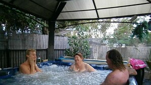 Un bain à remous où se trouvent trois personnes.