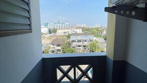 A balcony with a view of buildings and a fan. - Sakun Place (Samut Prakan)