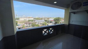 A room with a balcony overlooking a cityscape. - Sakun Place (Samut Prakan)