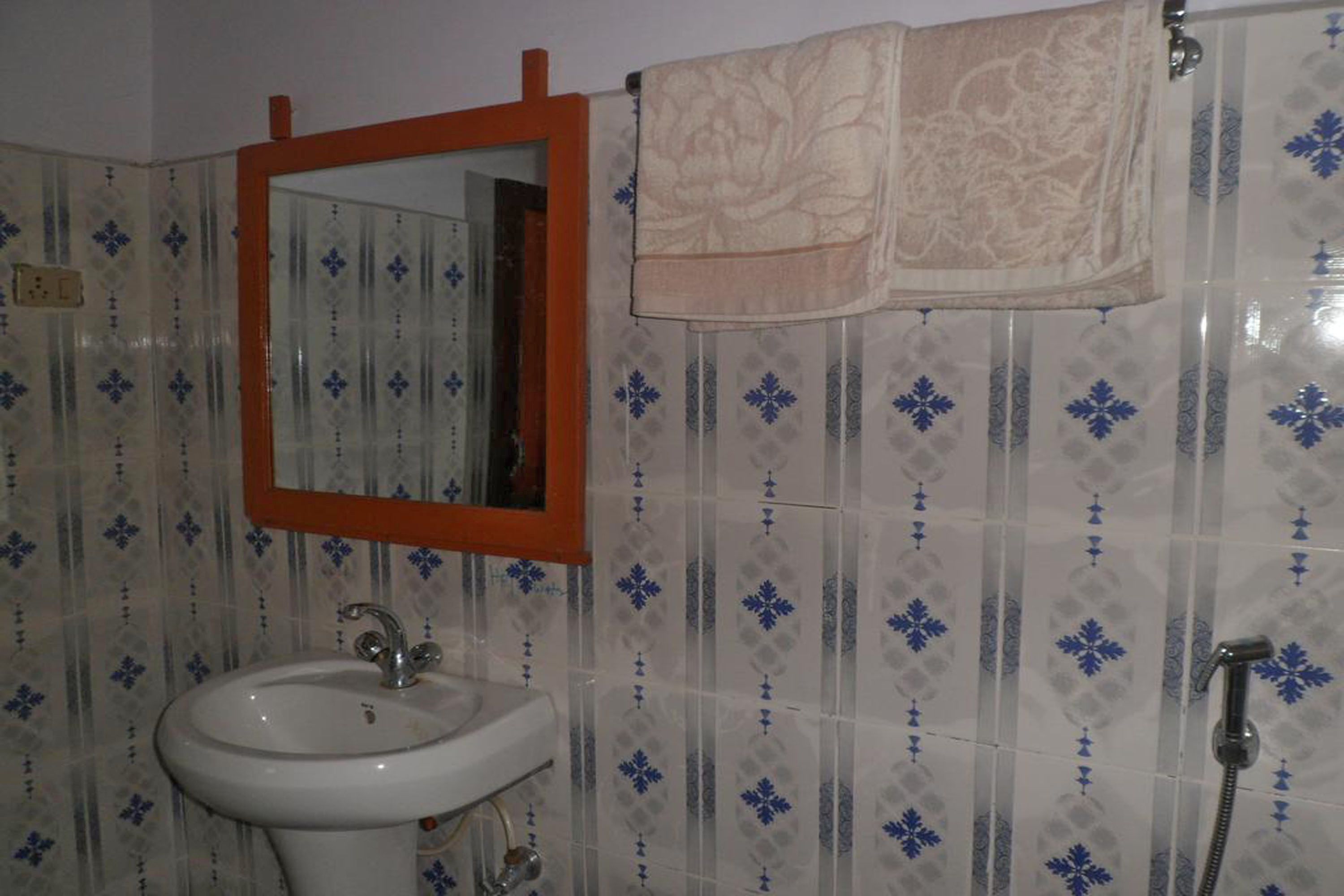 A bathroom with a sink, mirror, and shower.
