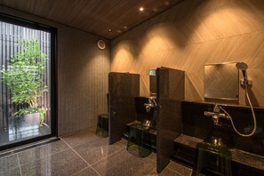 Un baño moderno con un ventanal grande, zona de ducha y retrete.
