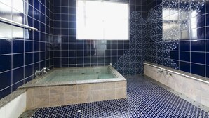 A bathroom with dark blue tiles, a bathtub, and a window. - Tamagawa Ryokan (Tahara)