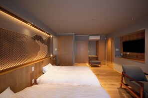 Una habitación de hotel moderna con dos camas, una zona de estar, un televisor montado en la pared y un diseño de pared estampado.