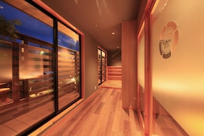A modern interior with a wooden floor, glass doors, and a staircase. - Tamagawa Ryokan (Tahara)