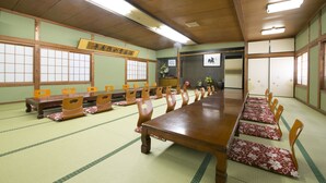 A traditional Japanese room with tatami flooring, wooden tables, and chairs. - Tamagawa Ryokan (Tahara)
