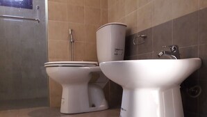 Um banheiro com vaso sanitário, bidê e pia.