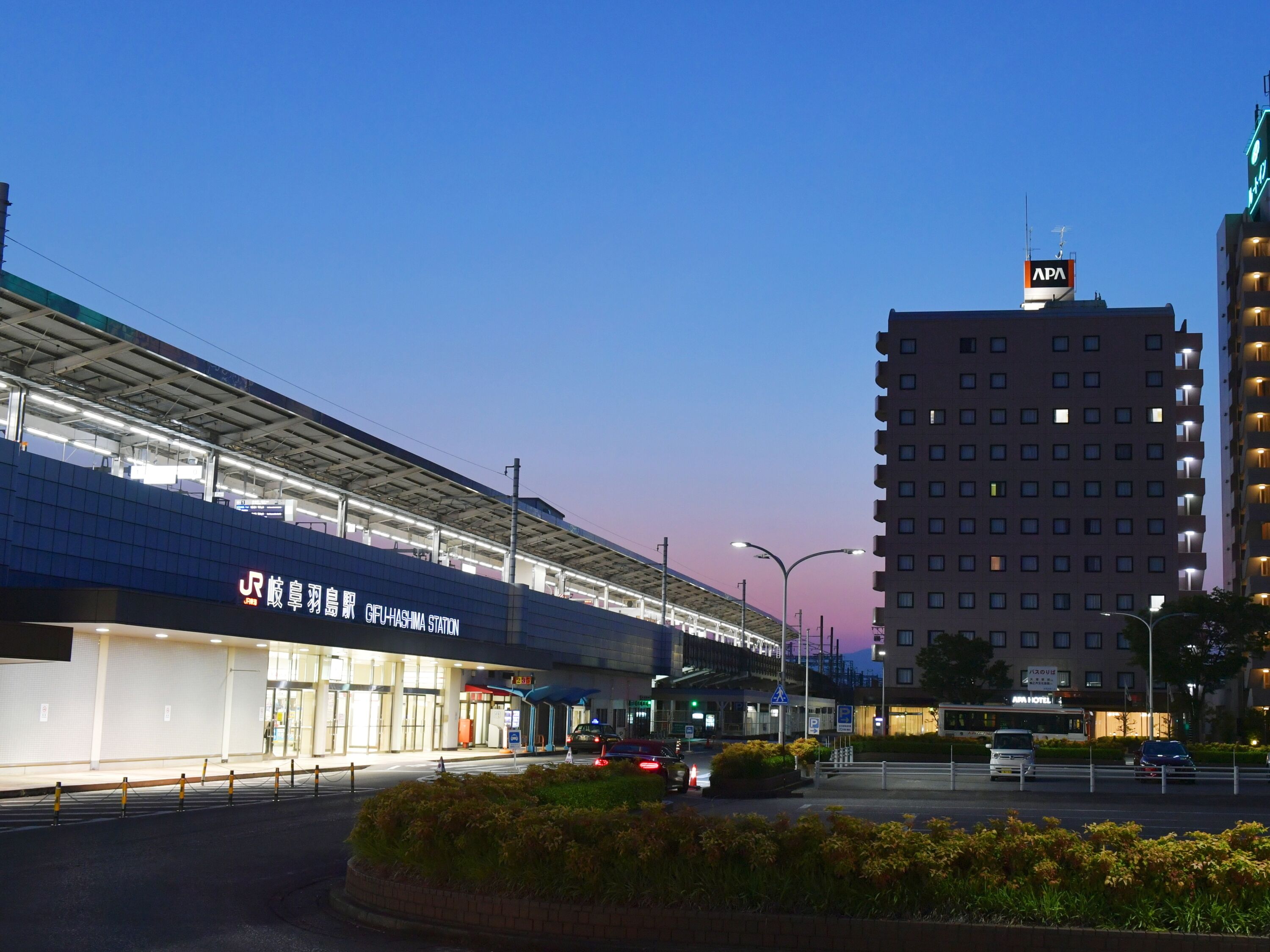 Un bâtiment moderne, sur lequel on peut voir une enseigne indiquant la station GFU Hashima, et un hôtel appelé APA.