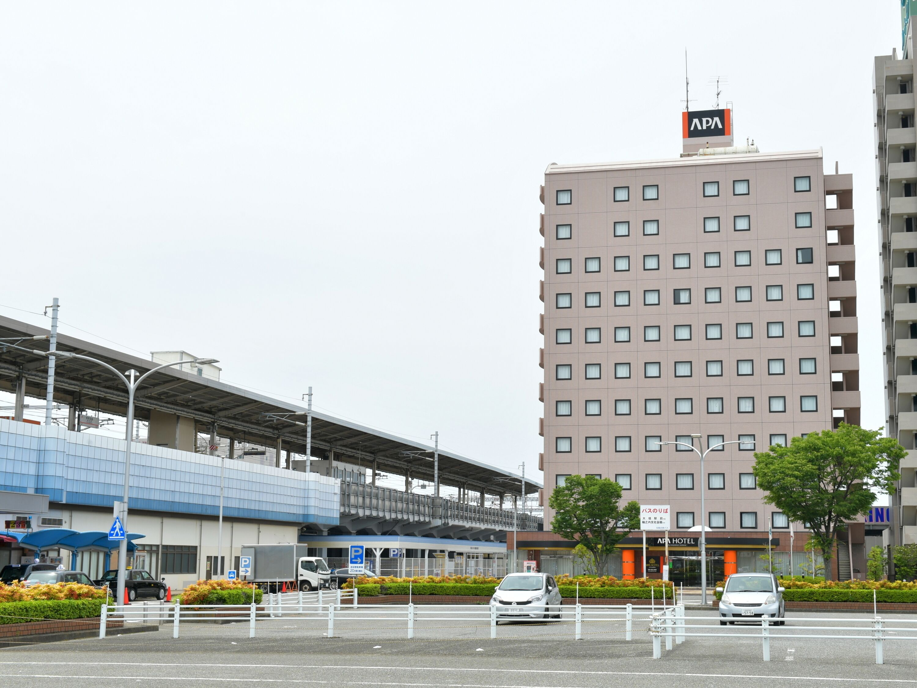 Un edificio moderno con un letrero que dice “APA HOTEL” en la fachada.