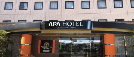 APA Hotel features a striking entrance with a prominent name display and modern architectural design.