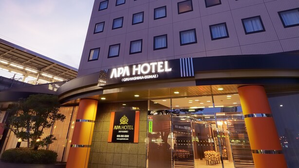 Das äußere Erscheinungsbild des APA Hotels mit moderner Fassade, großen Fenstern und einem markanten Eingang.