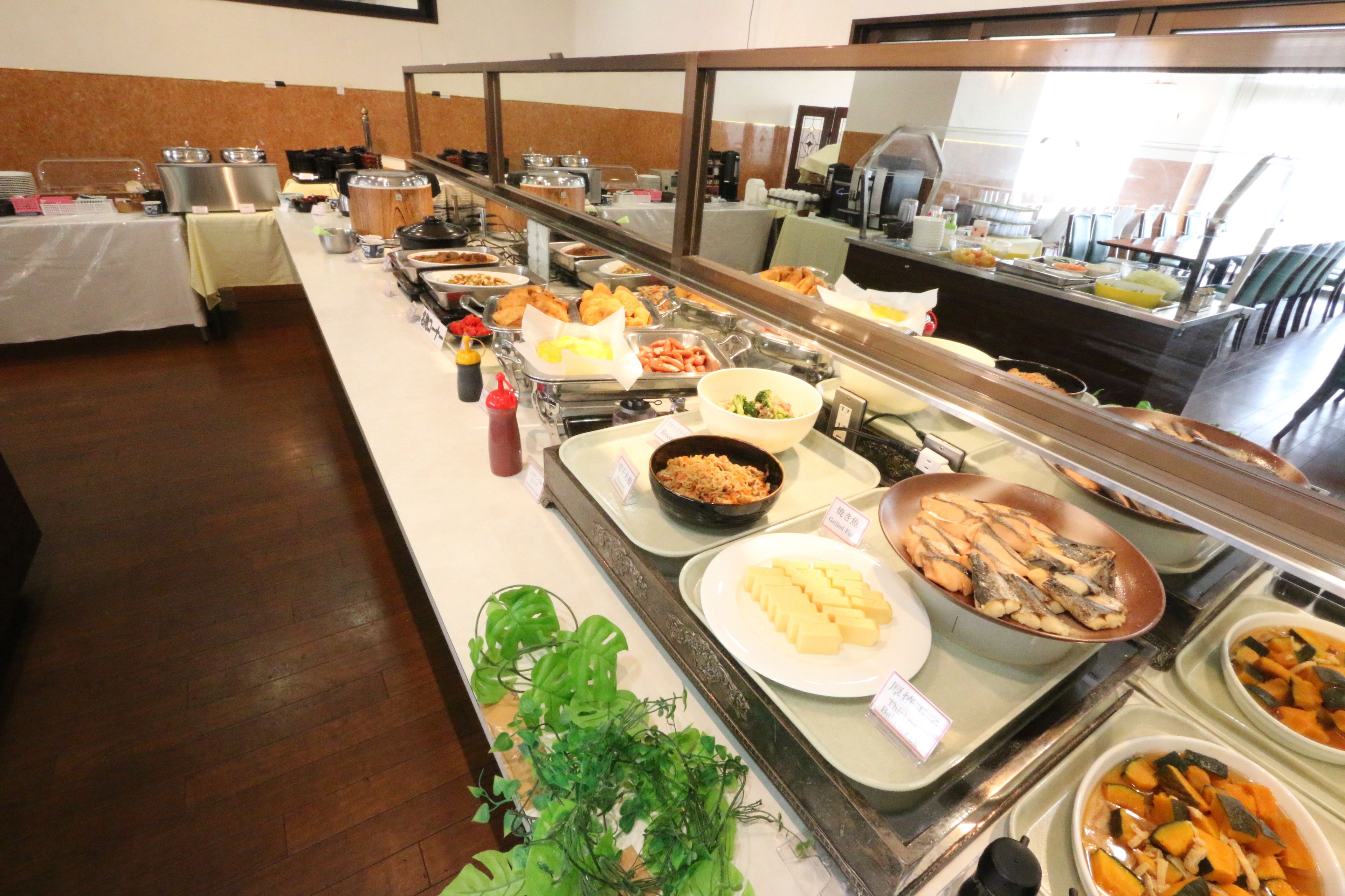 Un buffet garni de divers plats et un miroir qui reflète la pièce.