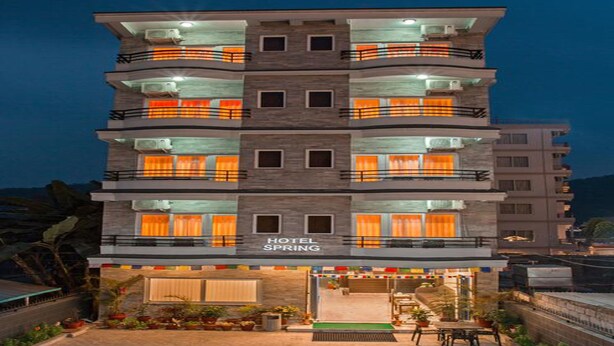 Un hotel de varios pisos con balcones y un letrero que dice "HOTEL SPRING".