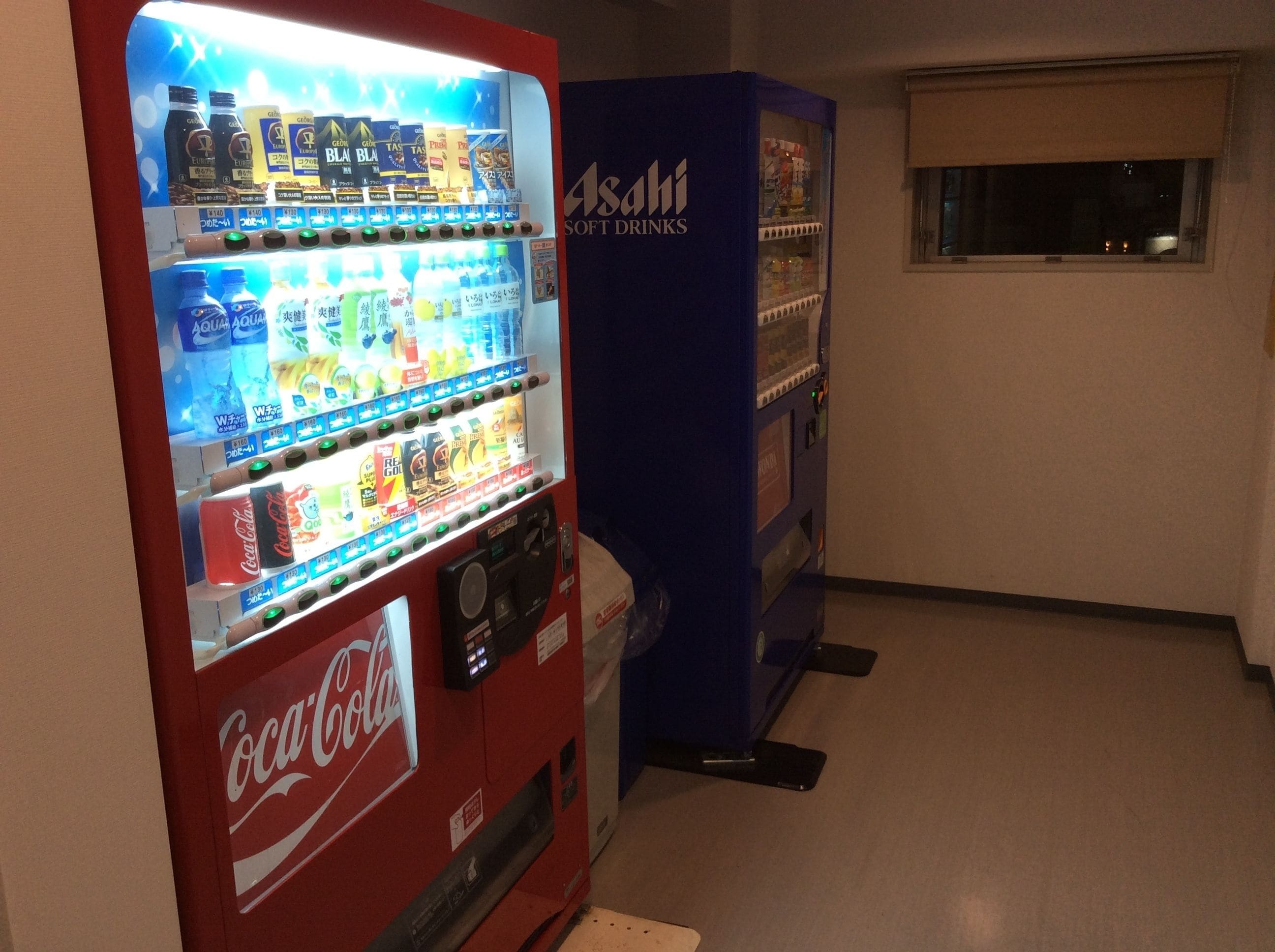 A vending machine with Coca-Cola and Asahi Soft Drinks.