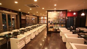 Zona de bar con asientos y exhibición de botellas de licores.