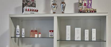 Una estantería con varios productos para el cuidado de la piel, incluyendo marcas como Allprosen y arcaya.
