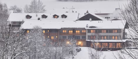 Monikerroksinen rakennus, jossa on useita ikkunoita ja lumipeitteinen katto.