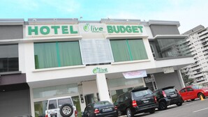 Un hotel llamado "HOTEL LIVE BUDGET" con una fachada moderna y ventanas amplias.