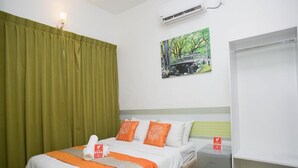 Una habitación de hotel con cama, mesita de noche, armario y un cuadro en la pared.