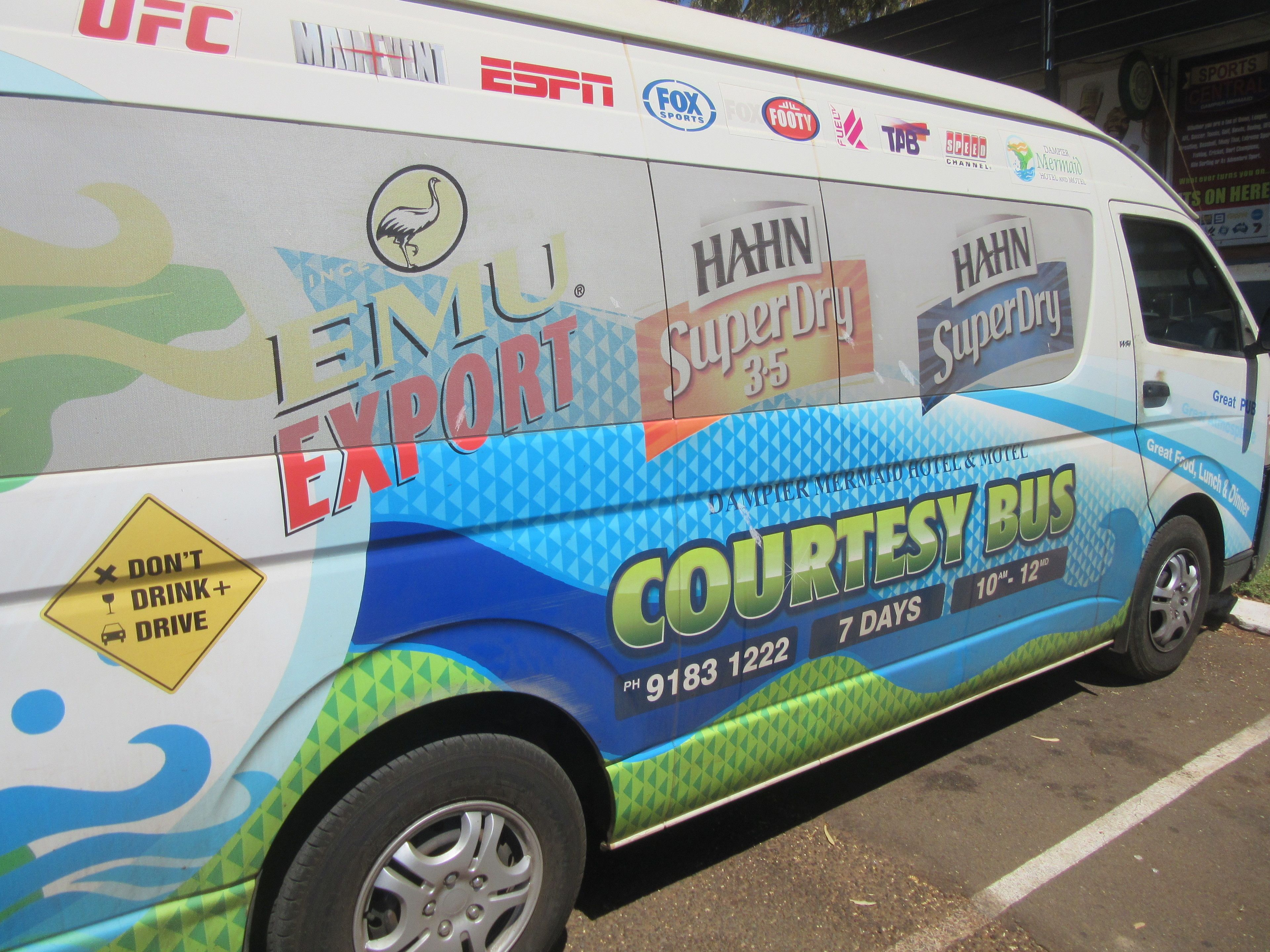 Un autobus arborant de nombreuses publicités et logos, notamment ceux de « UFC », « ESPN », « FOX SPORTS » et « HAHN SuperDry ».
