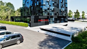 Moderni hotellirakennus, jossa on lasijulkisivu ja kyltti, jossa lukee:   ”CoolMama Hotel”.