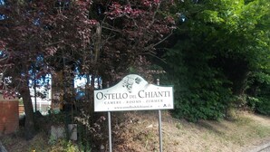 Een bord voor Ostellodelli Chianti, met faciliteiten zoals kamer, kamerinrichting en roomservice.