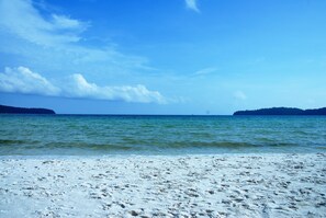 Ein Strand mit klarem, blauem Wasser und einem sandigen Ufer.