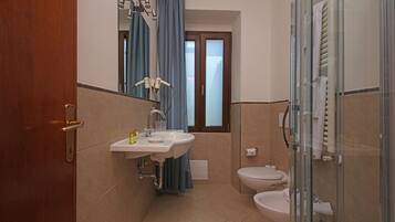 Un bagno con lavandino, specchio e due servizi igienici.