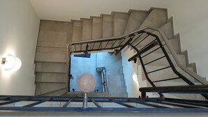 A staircase with a metal handrail and a circular object at the bottom. - urlaubsart - Am Rathaus (Kappeln)