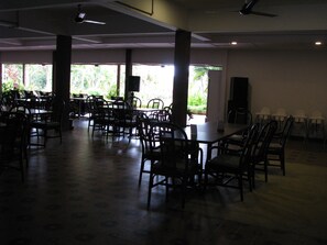 A spacious indoor area with multiple tables and chairs arranged for dining.