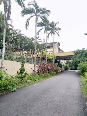 A paved road with a fence on one side and a building with a flat roof in the background. - Mersing Merlin Inn (Mersing)